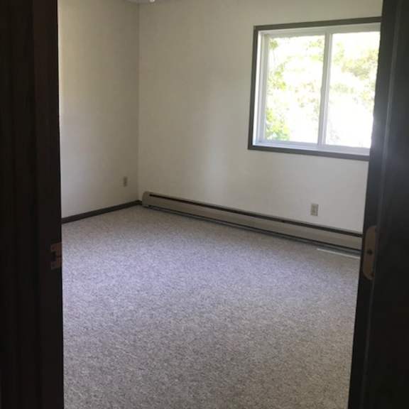 a room with a ceiling fan and a window.