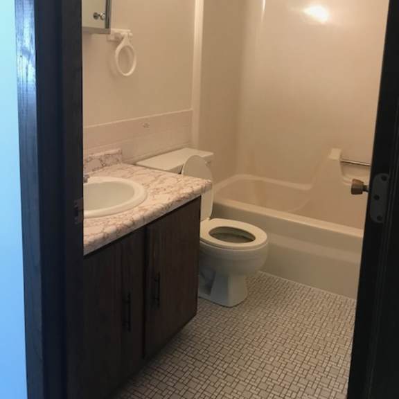a bathroom with a toilet, sink, and bathtub.