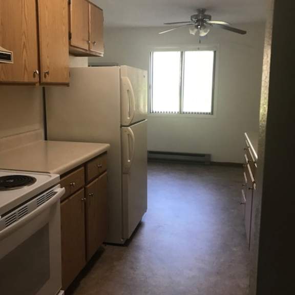a kitchen with a white stove and refrigerator.