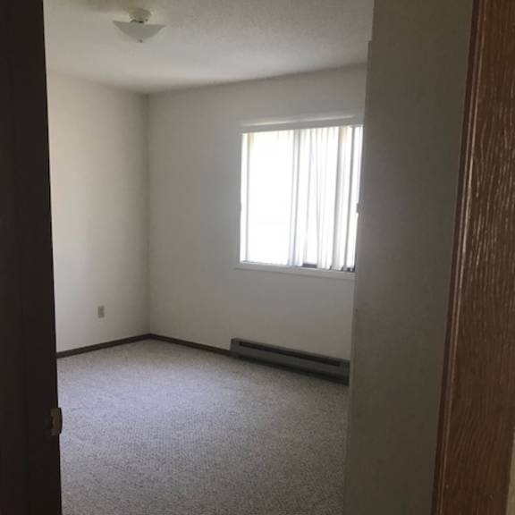 a room with a window and carpeted floor.