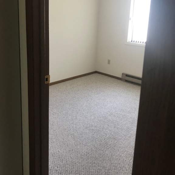 a room with a carpeted floor and a window.