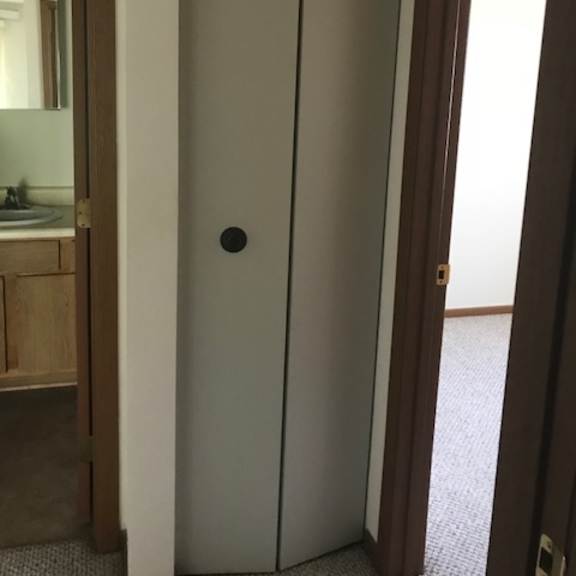 a white door with a black handle is in a room.