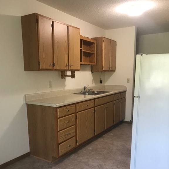 a kitchen with wooden cabinets and a white refrigerator.