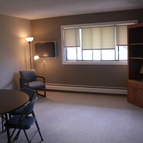 a room with a table, chairs, and a television.