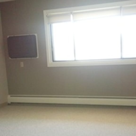a room with a window and a speaker on the wall.