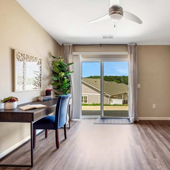 an office with a sliding glass door and a view of a house