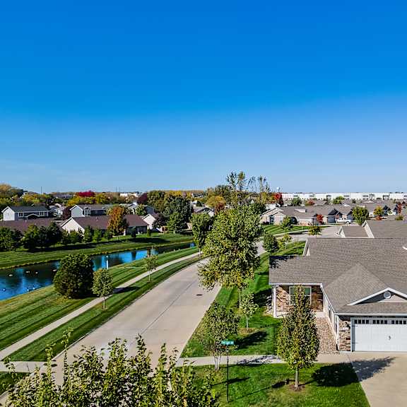 a residential neighborhood with houses and a pond.