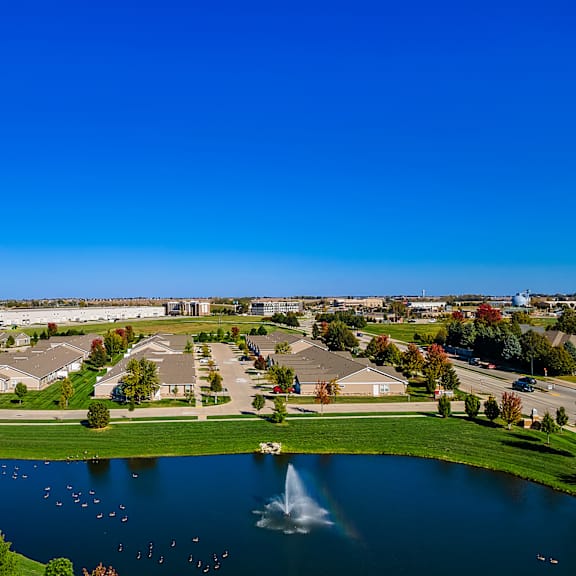 a lake in a housing development with a fountain in the middle.