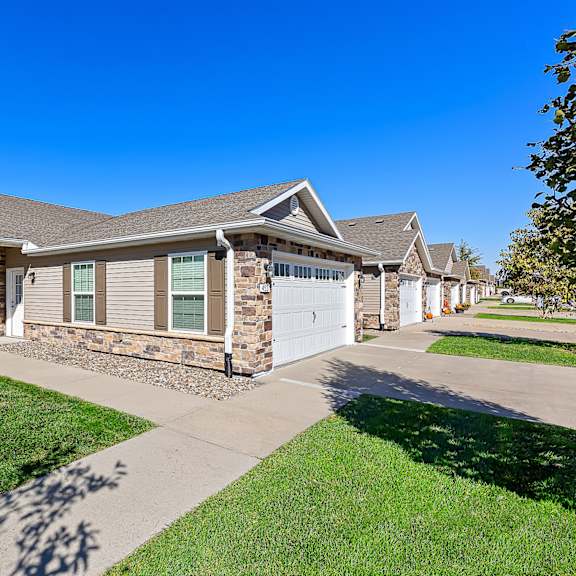 a house with a stone wall and a garage door.