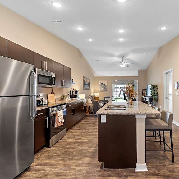 a kitchen with a refrigerator, microwave, and oven.