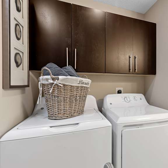 a laundry room with a basket on top of a washing machine.