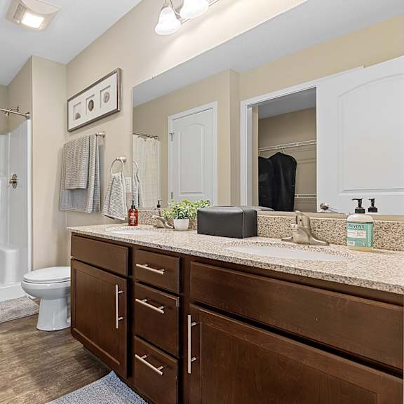 a bathroom with a toilet, sink, and shower.