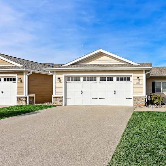 a two-story house with a garage and a driveway.