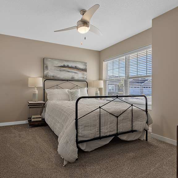 a bedroom with a bed, nightstand, and a painting on the wall.