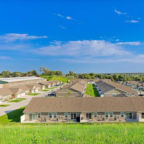 a large grassy field in front of a housing development.
