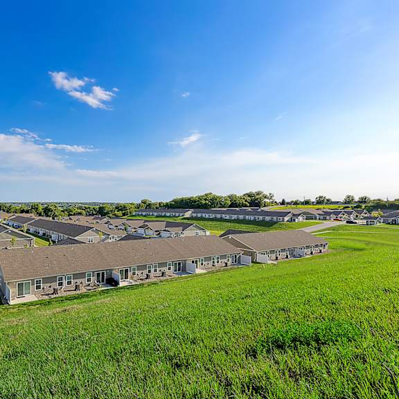 a row of houses with a grassy field in front.