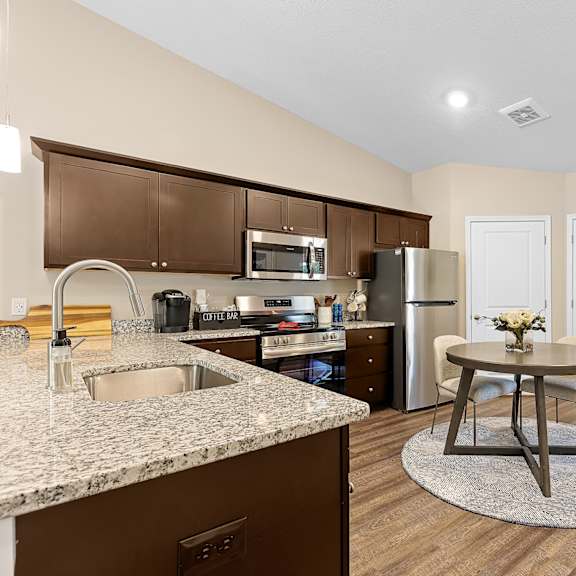 a kitchen with brown cabinets and a granite countertop.