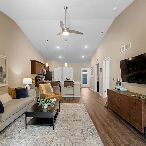 a living room with a couch, coffee table, and a ceiling fan.