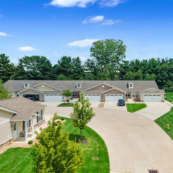 a row of houses with driveways in front of them.