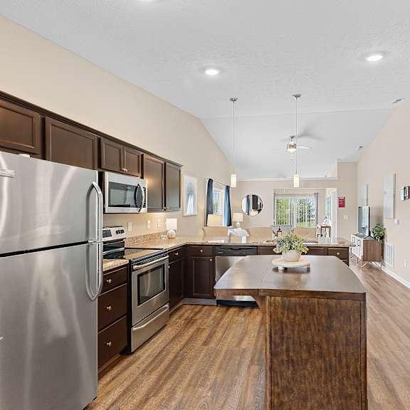 a modern kitchen with a wooden island and stainless steel appliances.