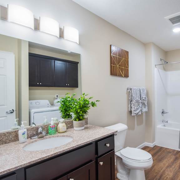 a bathroom with a white toilet, sink, and shower.