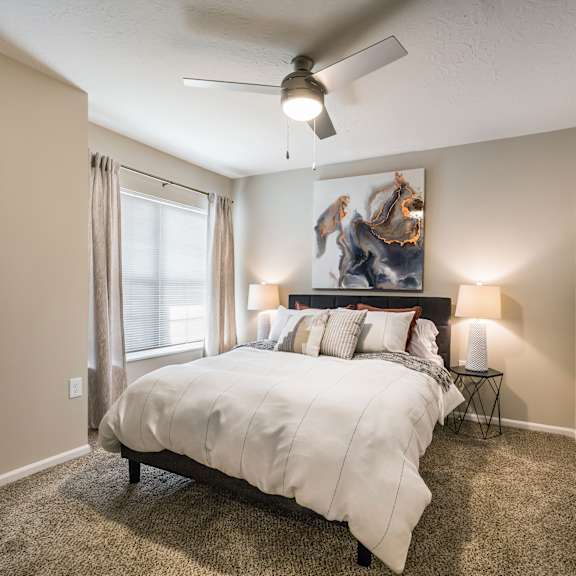 a bedroom with a large bed and a ceiling fan.