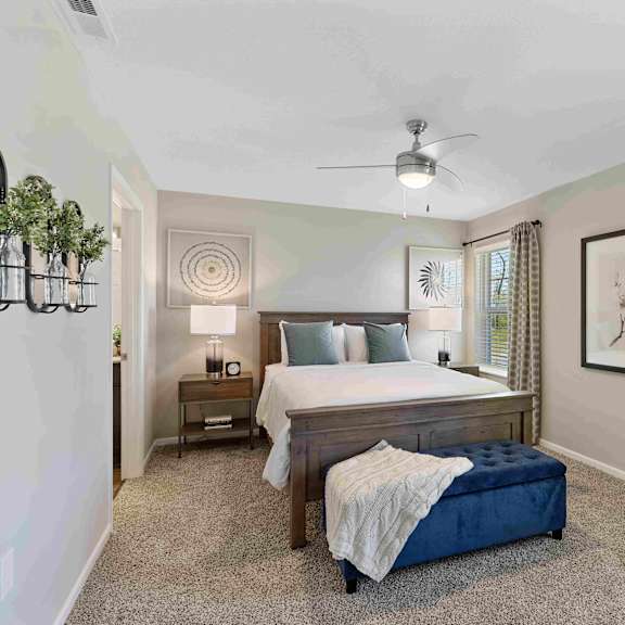 a bedroom with a bed, nightstand, and a plant on the wall.