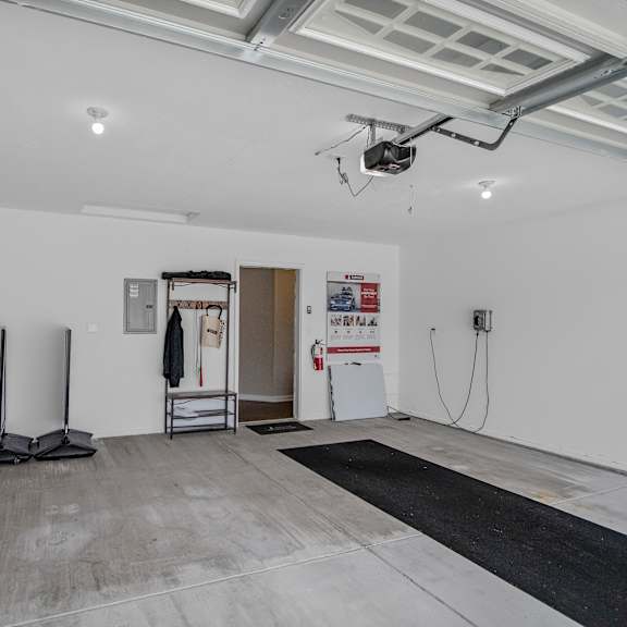 a room with a black mat on the floor and a white wall with a doorway leading to another room.