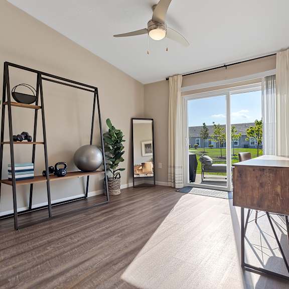 a room with a wooden floor and a sliding glass door leading to a balcony.