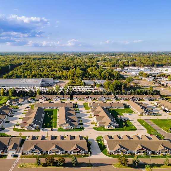 a bird's eye view of a residential area with houses and a parking lot.