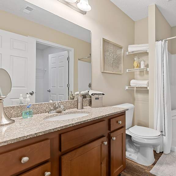 a bathroom with a white toilet and a white shower.