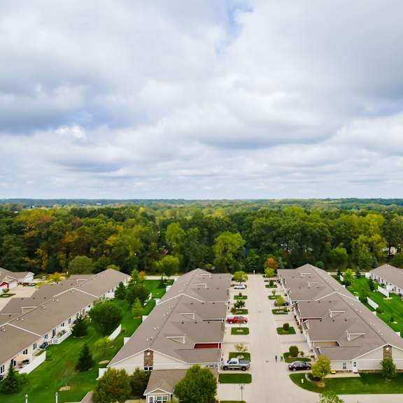 a suburban neighborhood with houses and cars parked in front.