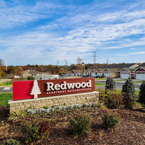 a sign for redwood apartment neighborhood in front of some houses.