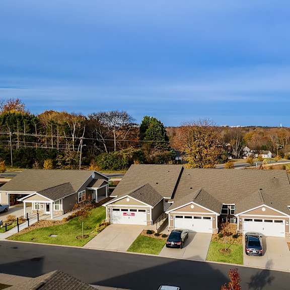 a suburban neighborhood with houses and cars parked in front.