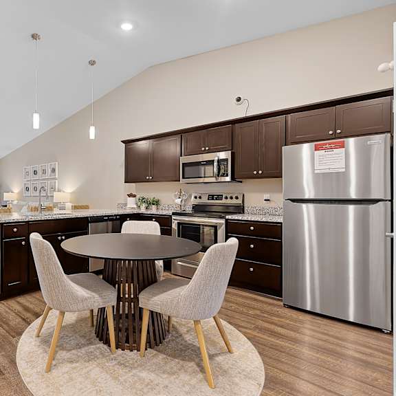 a modern kitchen with a large island and a dining table set for four.