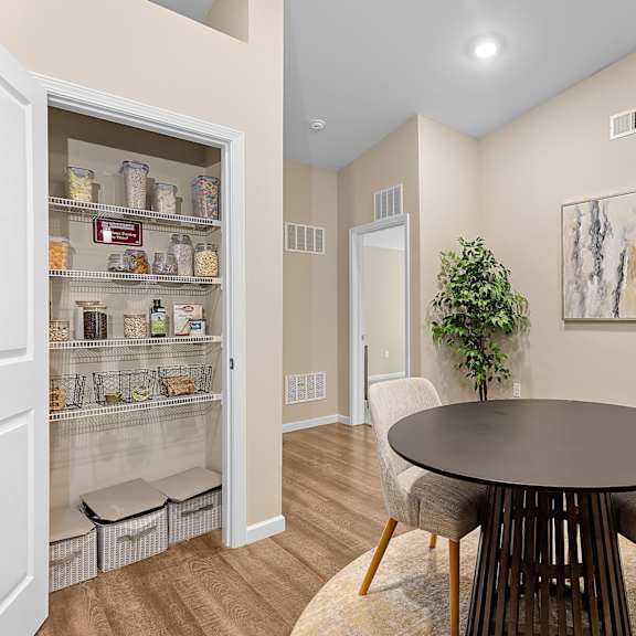 a dining room with a table and chairs and a potted plant.