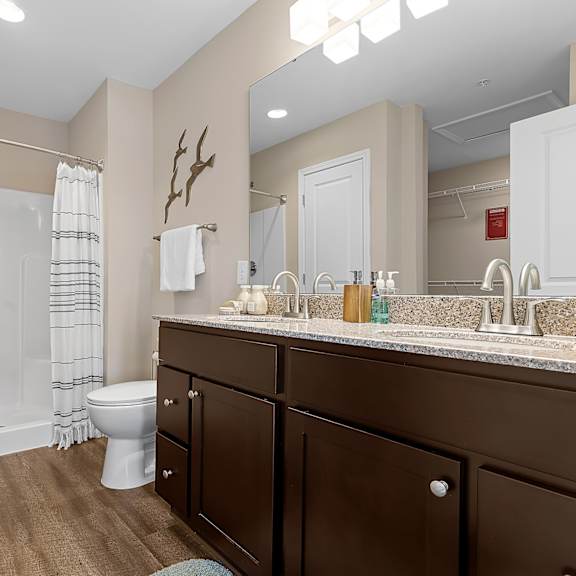 a bathroom with brown cabinets and a white toilet.