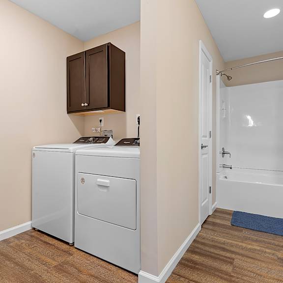 a bathroom with a white toilet and a white sink with a cabinet above it.
