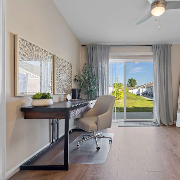 a room with a desk, chair, and a hanging chair with a view of the outside.