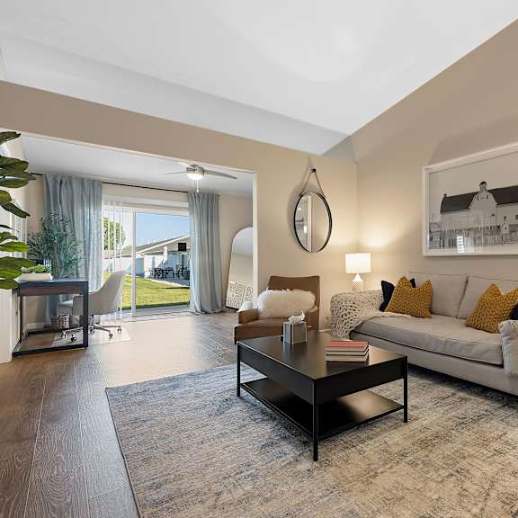 a living room with a white couch, a coffee table, and a painting on the wall.