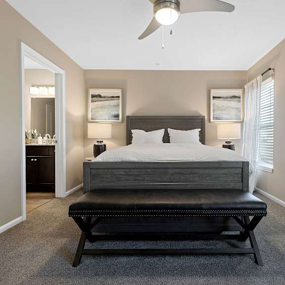 a bedroom with a bed, nightstand, and a ceiling fan.