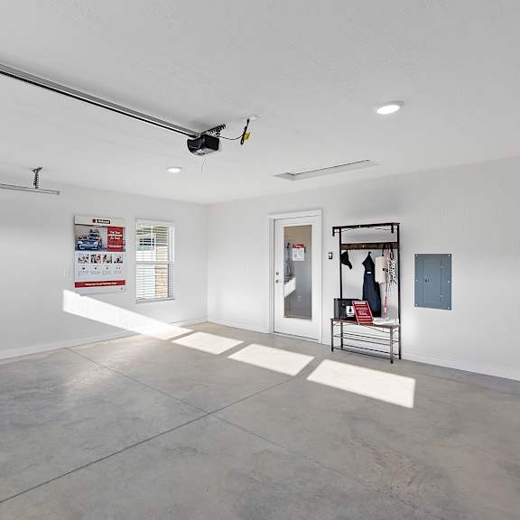 a white gallery with a bench and posters on the wall.