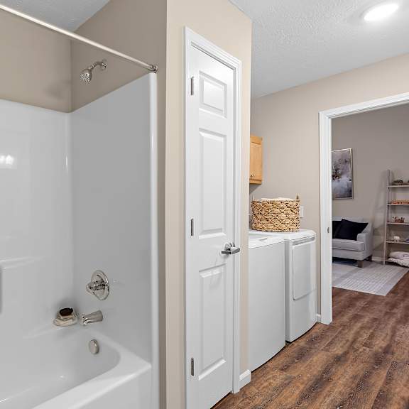 a white bathroom with a white tub and a white door.