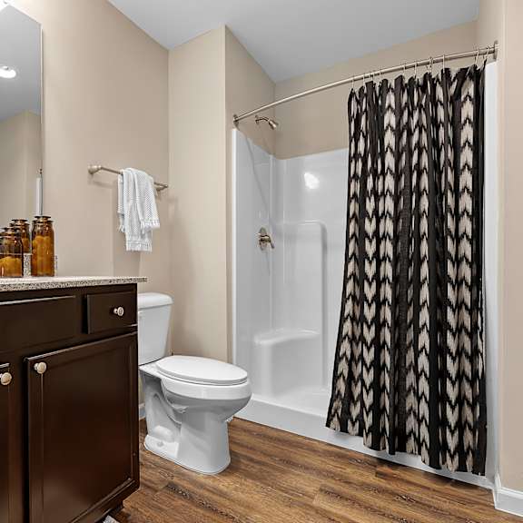 a bathroom with a toilet, sink, and shower.