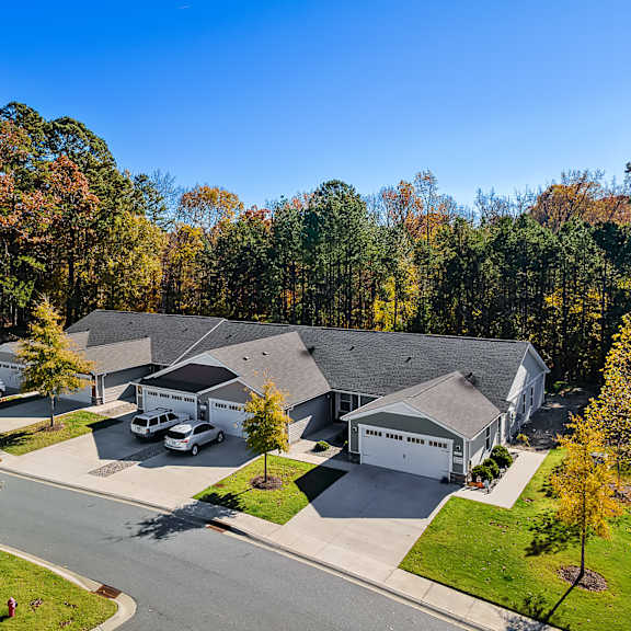 a large house with a garage is surrounded by trees.