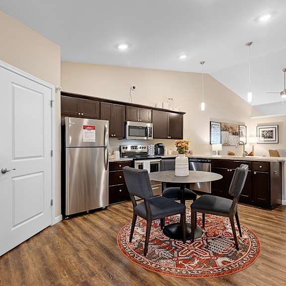 a kitchen with a table and chairs in the middle of the room.