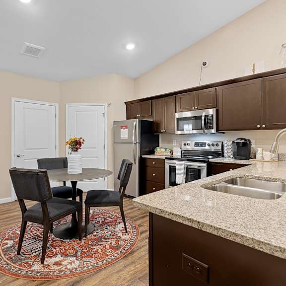 a kitchen with a table and chairs in the middle of the room.
