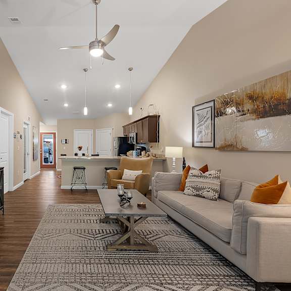 a living room with a white couch and a wooden floor.