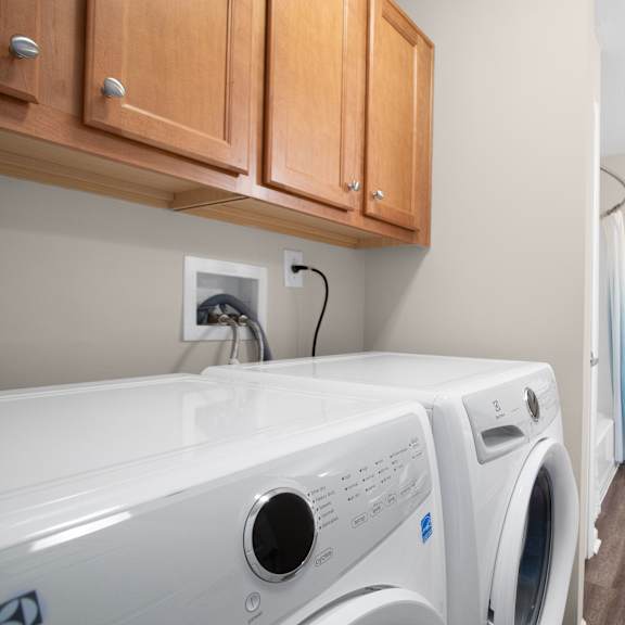 a white washing machine and dryer in a laundry room.