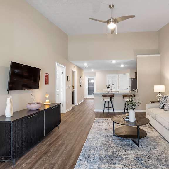 a living room with a white couch, a black cabinet, and a ceiling fan.